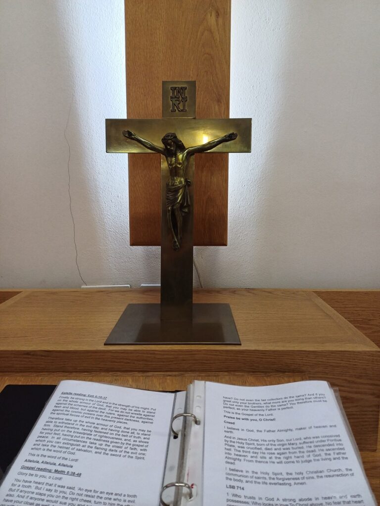A close-up of the brass cross on the altar