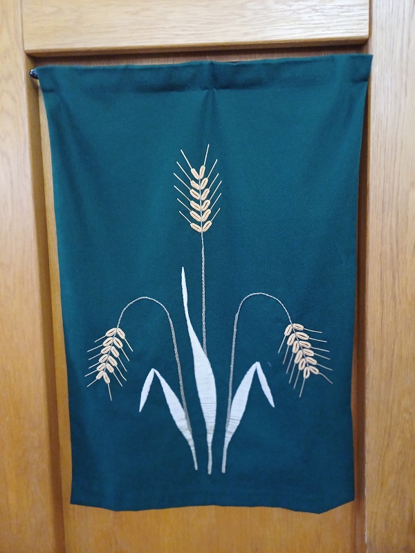 Pulpit cloth showing embroidered ears of corn on a green background